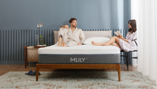 Couple relaxing together on a MLILY memory foam mattress in a bright bedroom