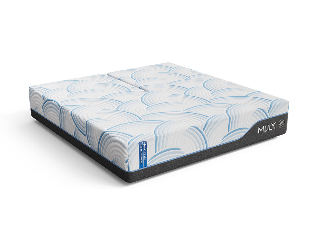 Angled view of the WellFlex ICE Split Head King mattress, showing its split-top design, white and blue patterned cover, and charcoal side panels.
