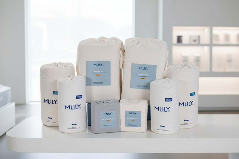 Collection of MLILY bedding bags on a white surface with a blurred background