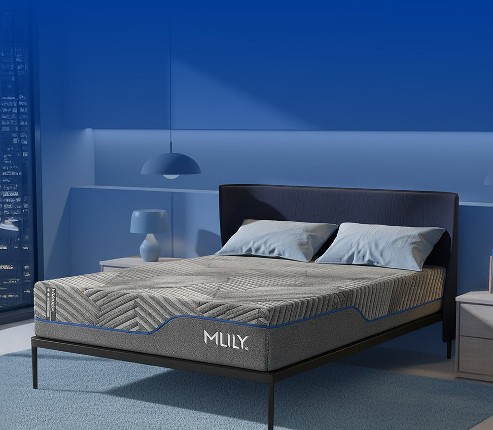 Gray mattress with 'MLILY' branding on a bed in a room with blue walls.