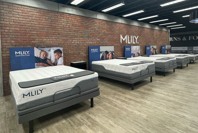 MILY mattresses on display in a store with brick walls and visible branding.
