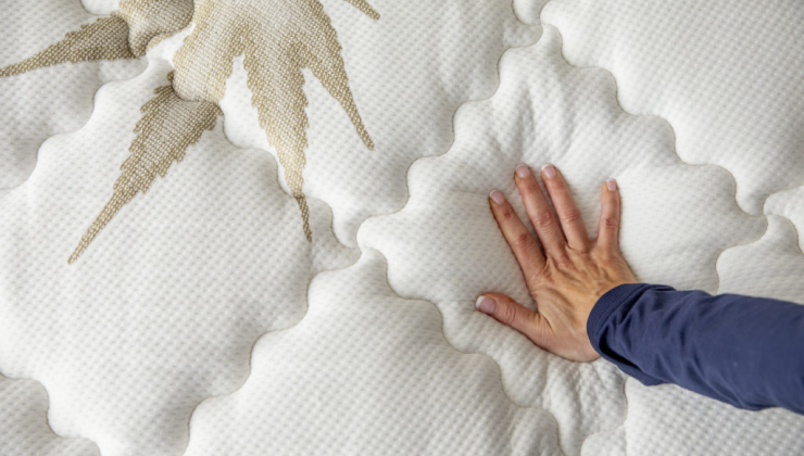 close up image of hand pushing down on memory foam mattress